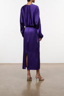 Purple silk midi dress with low back and long sleeves; front slit at hem