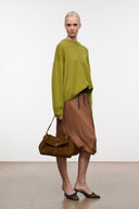 Cigar brown suede handbag with flap and short handles, worn over shoulder