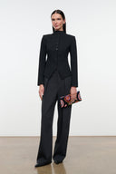 Black long-sleeve jacket with high collar, button front, and sculpted peplum detail