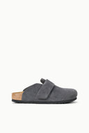 A single dark gray suede clog shoe with a hook-and-loop strap and a natural cork footbed, shown in profile against a plain white background.