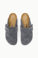 A pair of gray suede clogs with a wide strap across the instep, shown from a top-down view on a white background. The tan insoles display the brand name 'BIRCH'.