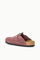 A single burgundy suede clog slipper with a black sole and a natural cork footbed, shown from a side profile on a clean white background.