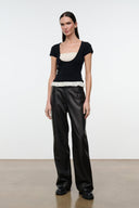 Black knit top with scoop neckline and ivory ruffled hem