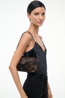 Leopard-print shoulder bag with flap, dark straps, and small rounded top handle.
