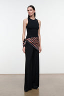 Silk scarf with multicolor geometric stripe pattern wrapped at waist with black dress
