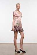 Pink silk dress with fitted bodice and floral print, black polka-dot ruffle hem