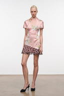 Pink silk dress with short sleeves, floral print, and black polka-dot ruffle hem