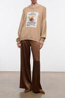 Beige knit sweater with long sleeves, crew neck, and centered text-art graphic