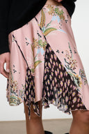 Pink silk skirt with black and green floral tapestry print, draped mid-length hem