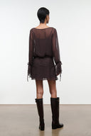 Dark brown sheer long-sleeve mini dress with ruched waist and tie-cuff details, back view.