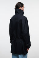 Black high-neck jacket back view with belt at waist and buttoned cuff tabs