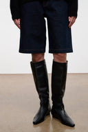 Black knee-high flat pull-on boots, pointed toe and low stacked heel