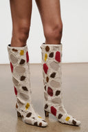 Back view of tall suede patchwork boots with cream base and red, brown, and yellow hearts