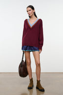 Burgundy V-neck sweater with multicolor collar border and ribbed cuffs