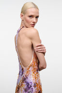 Backless sleeveless maxi dress with low scoop back; orange and purple abstract print.