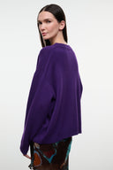 Relaxed cashmere crewneck sweater in deep purple, long sleeves, side view.