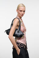 Black mini shoulder bag with top handle, short strap, and metal hardware