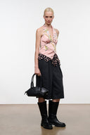 Black mini shoulder bag held at front with short strap and ring hardware