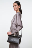 Espresso leather cuff clutch with short strap, carried at side