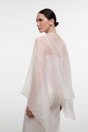 Ivory top with high neckline and draped cape sleeves, back view