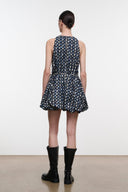 Back view: navy sleeveless mini dress with teardrop print and flared pleated skirt