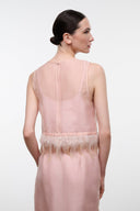 Back view: pink sheer sleeveless top with thin straps and feather fringe hem