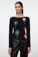 Black long-sleeve top with multicolor circular embroidery and tassels, crew neck