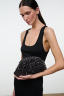 Black and silver beaded fringe clutch bag held at chest level