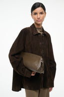 Snakeskin-pattern soft clutch held by model with zip top and side straps