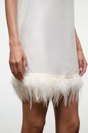 Ivory sleeveless mini dress close-up: feather fringe hem detail