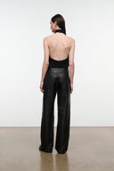 Back view of black leather pants with straight wide legs and center seam