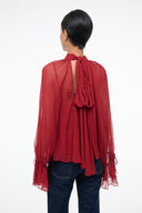 Pomegranate red sheer blouse with tied back bow and ruffled high neck
