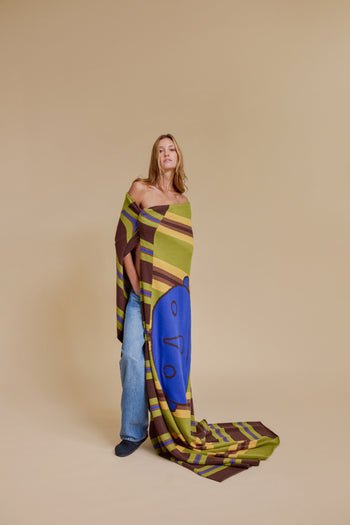 Cashmere blanket draped on model, multicolor stripe design with blue owl print