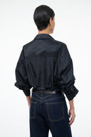 Black button-front bodysuit, back view, pointed collar and long cuffed sleeves