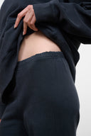Washed black terry sweatpants with elastic waistband and wide straight legs