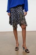 Silk skirt close-up: navy multicolor dot print with fringed asymmetric tiers