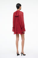 Pomegranate red mini dress with back tie bow at neck and sheer long sleeves