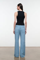 Sky blue suede pants viewed from the back, with patch pockets and wide legs.