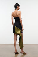 Back view: strapless black mini dress with olive-gold drape and pocket-like fold