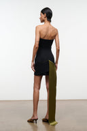 Back view: black strapless mini dress with tall olive-gold draped tail