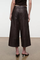Dark brown leather culottes with wide cropped legs and back yoke seam, side view.