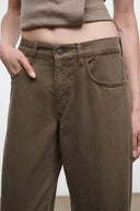 Relaxed dark olive jeans showing front pocket, belt loops, and button fly