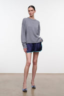 Dark navy sleep shorts with teal elastic waistband and turquoise piping, model side view