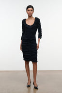 Black ruched midi dress with ruffled shoulders and long fitted sleeves.