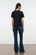 Back view of medium-wash flare jeans with stitched yoke and two back pockets