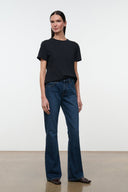Front view of medium-wash flare jeans with button fly and straight-to-flare leg