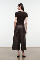 Dark brown leather culottes shown from back with wide cropped legs and straight yoke.