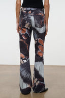 Flare jeans with abstract butterfly print, dark base, orange highlights, black rib waistband