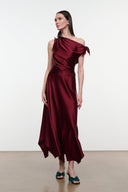 Deep burgundy silk midi dress with one-shoulder drape and flowing asymmetrical hem
