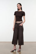 Dark brown leather culottes with button waist and wide cropped legs, full front view.